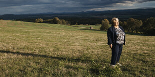 Eine Frau steht auf einem Feld in der Abendsonne