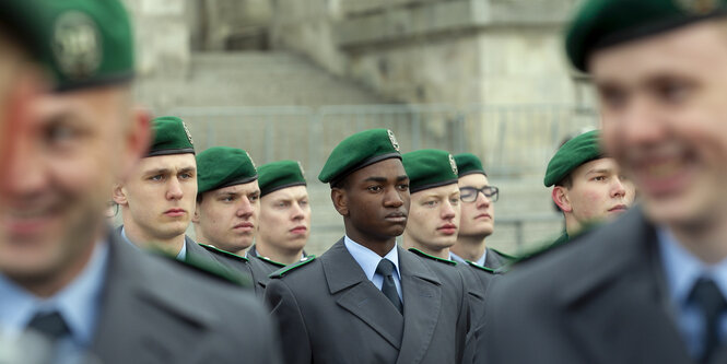 Die Rekruten des Wachbataillons der Bundeswehr in Reih und Glied, einige mit ernsten, einige mit lachenden Gesichtern