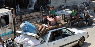 Palästinensische Kinder sitzen auf dem Dach eines vollgepackten Autos. Die Menschen fliehen aus dem Maghazi Flüchtlingscamp nach einer Evakuierungsanordnung der israelischen Armee.