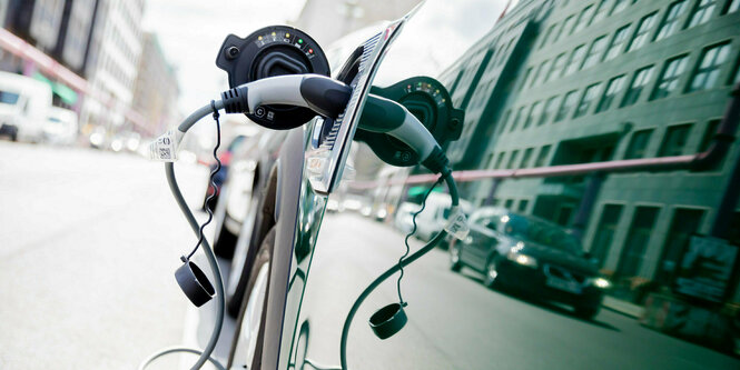 Ein Auto mit Plug-in-Hybrid-Antrieb lädt in Berlin-Mitte an einer Ladesäule.