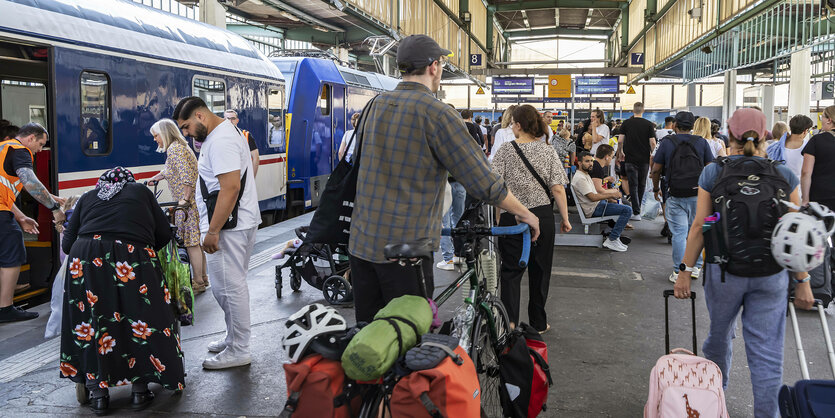 Menschen mit Reisegepäck auf einem Bahnhof