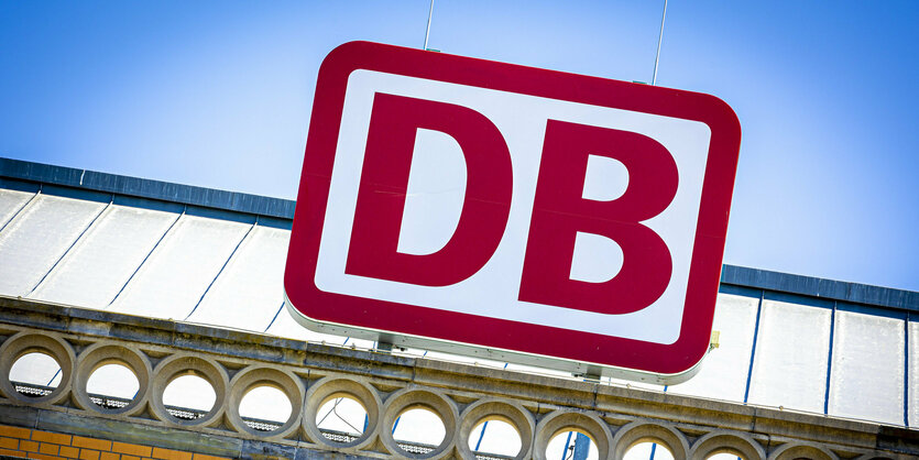 Das Deutsche Bahn-Logo auf dem Dach eines Bahnhofs.