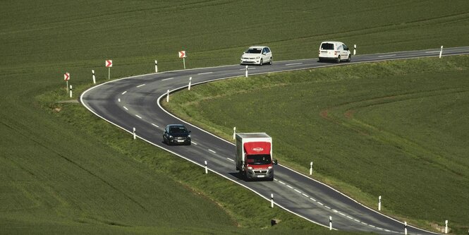 mehrere Autos auf einer Landstrasse, die eine scharfe Kurve macht