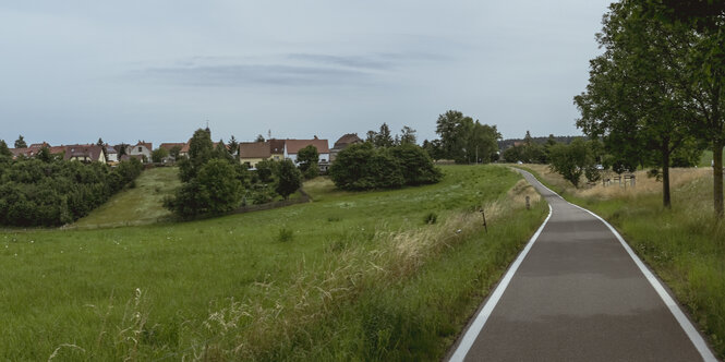 Eine schmale Straße am Rande eines Dorfes