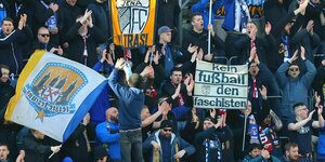 Fussballfans vom FC Carl Zeiss Jena mit Bannern und Flaggen. Auf einem Banner steht: kein Fussball den Faschisten