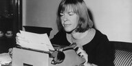 Eine schwarz-weiß Aufnahme von Ingeborg Bachmann während sie auf einer Schreibmaschine tippt