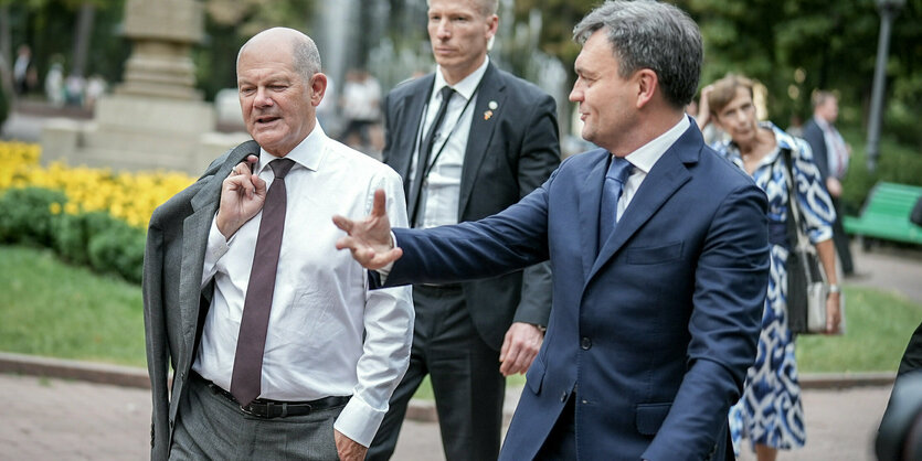 Scholz mit Jacket über der Schulter und Moldaus Ministerpräsident Dorin Recean am Mittwoch beim Gang durch die moldauische Hauptstadt Chisinau