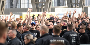 Teilnehmer einer rechtsextremen Versammlung im Hauptbahnhof Leipzig zeigen das neonazistische Symbol von white power