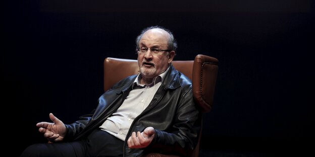 Salman Rushdie sitzt in einem braunen Sessel