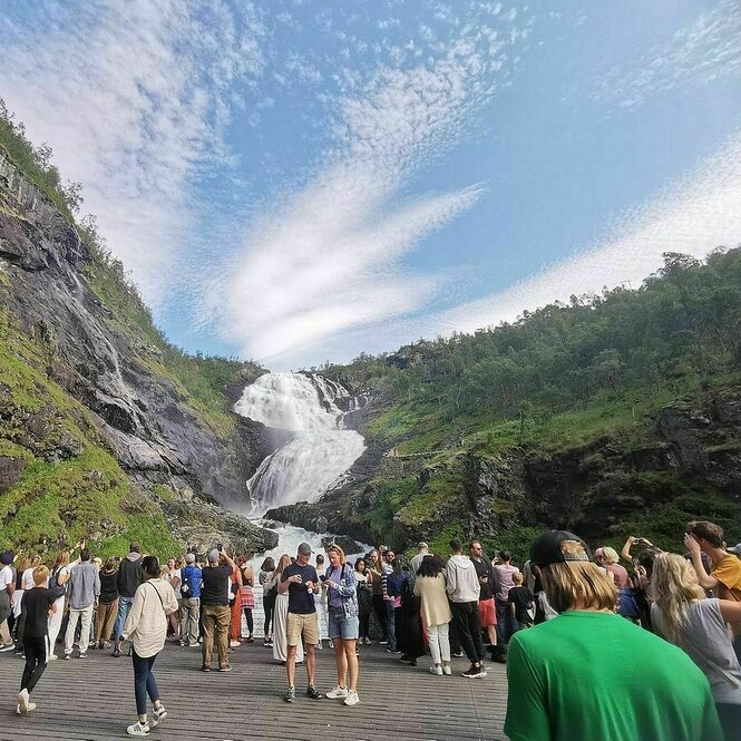 Menschen von hinten stehen an einem Wasserfall