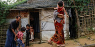 Geflohene Rohingya-Familie aus Buthidaung vor einer Hütte in einem Lager bei Cox's Bazar in Bangladesch