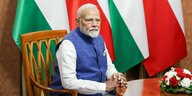 Indischer Premierminister Narendra Modi sitzt vor den Flaggen von Indien und Polen