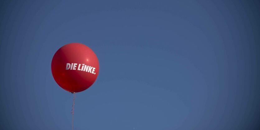 Ein roter Luftballon mit "Die Linke"-Aufschrift am Himmel