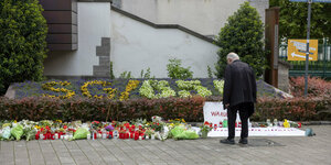 Ein Mann betrachtet Blumen die nach der Messerattacke auf dem Solinger Stadtfest in der Nähe des Tatortes niedergelegt wurden.