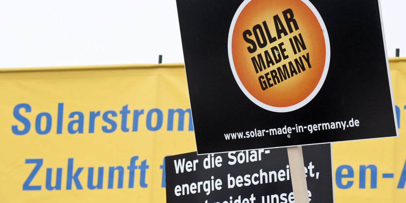 Protestplakate, auf denen steht "Solar made in Germany"