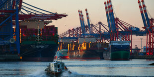 Kleines Schiff fährt vor Containerterminal