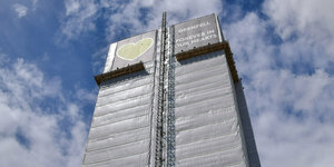 Der Grenfell Tower ist heute in silberne Folie eingekleidet, im oberen Bereich ein Banner mit grünem Herz und der Inschrift: Grenfell forever in our hearts