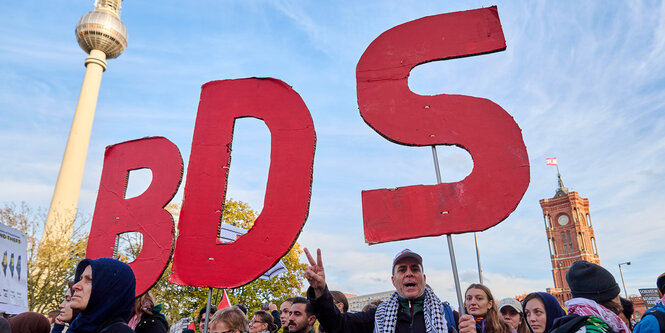 BDS in roten Buchstaben, gehalten vor dem roten Rathaus