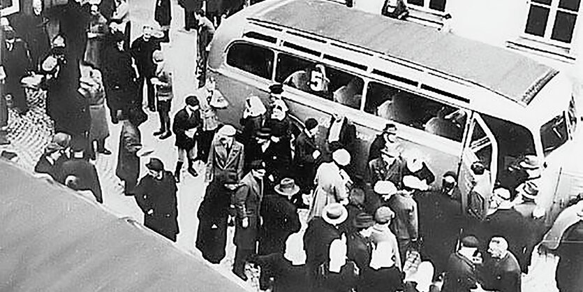 Ein historisches Foto aus der Nazizeit zeigt Menschen, die in einen Bus steigen.