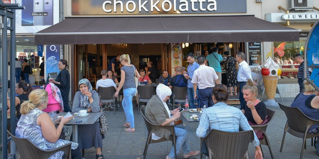 Menschen vor einem Straßenkaffee