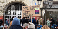 Ein Schild mit der Aufschrift "Sylterinnen gegen Rechts" wird in einer Menschenmenge hochgehalten