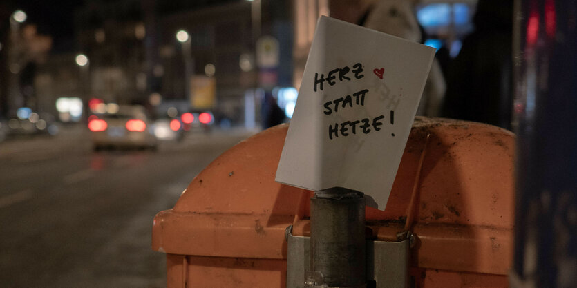 Ein Zettel an einer Laterne, auf dem steht "Herz statt Hetze"