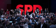 Delegierte stehen vor einem großen SPD Logo