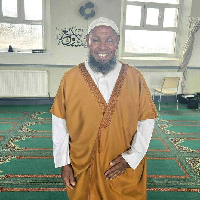 Porträt von Ibrahim Hussein, er steht in seiner leeren Moschee