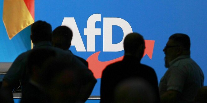 Schatten von Personen vor einem AfD-Logo