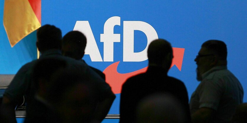 Schatten von Personen vor einem AfD-Logo