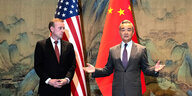 Wang Yi und Jake Sullivan stehen vor den Flaggen der USA und Chinas