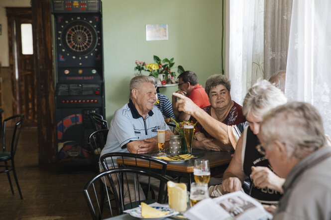 Menschen sitzen an Tischen im Lindenhof