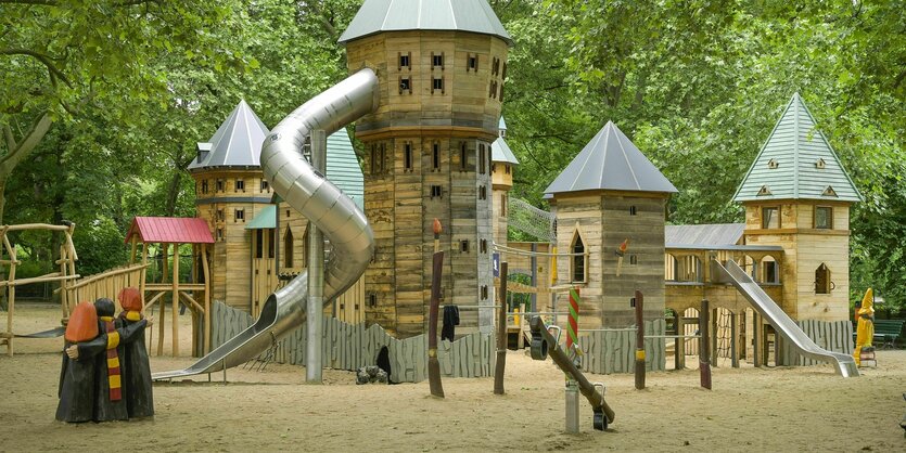 Der Zauberspielplatz steht auf Sand, die Klettergerüste und Rutschen sind in Türme aus Holz integriert und vermitteln den Eindruck einer mittelalterlichen Burg