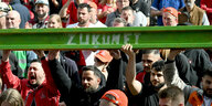 Stahlarbeiter halten symbolisch einen grün gestrichenen Stahlträger mit der Aufschrift "Zukunft" bei einer Protestkundgebung von Beschäftigten der Thyssenkrupp-Stahlsparte