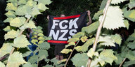 Teilnehmer einer Demonstration trägt ein Banner mit der Aufschrift «FCK NZS»