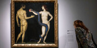 Das Bild "Adam und Eva" von Franz von Stuck. Daneben eine Besucherin, die eine Infotafel liest