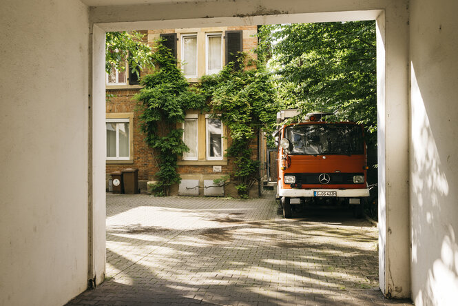 Ein rotes Feuerwehrauto parkt in einem Hof