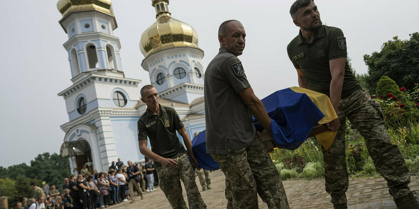 Ukrainische Soldaten der «18. Fliegerbrigade» tragen einen Sarg während einer Abschiedszeremonie für Piloten und Besatzungsmitgliedern der «Mi-8-Militärhubschrauber».