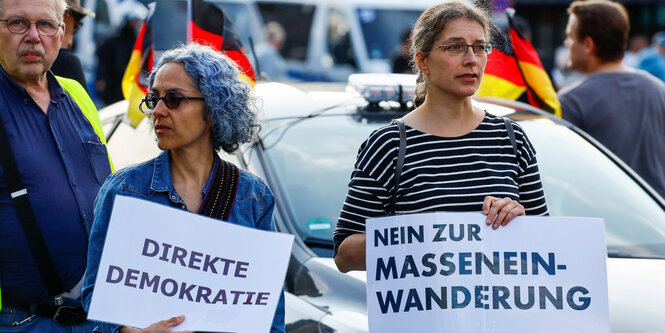 Zwei Demonstrantinnen in Solingen fordern direkte Demokratie und Remigration