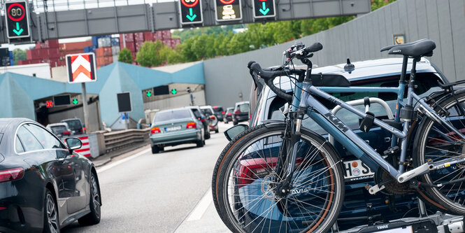 Autos stehen im Stau vor dem Elbtunnel, eines davon hat Fahrräder hinten drauf