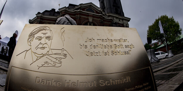 Eine Metall-Tafel mit einer Gravur des Porträts von Ex-Bundeskanzler Helmut Schmidt ist vor der Michaeliskirche aufgestellt.