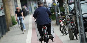 Ein Lastenrad auf einem Radweg und ein entgegenkommender Radfahrer