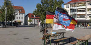 Auf einem Marktplatz wehen Deutschland und AfD Fahnen