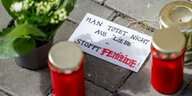 Blumen und Kerzen liegen nach einem tödlichen Messerangriff vor einem Hauseingang in Berlin-Friedrichsfelde neben einem Zettel mit der Aufschrift Man tötet nicht aus Liebe - Stoppt Femizide