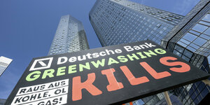 «Deutsche Bank - Greenwashing kills, raus aus Kohle, Öl und Gas!» steht auf einem Plakat, das Aktivisten aufgestellt haben