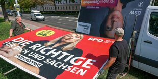 Mitarbeiter einer Werbefirma bauen ein Wahlplakat der SPD mit dem Bild der sächsischen Sozialministerin Köpping in der Landeshauptstadt ab