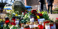 Blumen und Kerzen vor einem Einfamilienhaus.