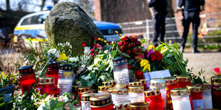 Blumen und Kerzen vor einem Einfamilienhaus.