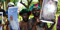 Papua-Studenten in traditioneller Kleidung halten Plakate mit Bildern des Papstes während einer Protestaktion vor der Vatikanischen Botschaft in Jakarta