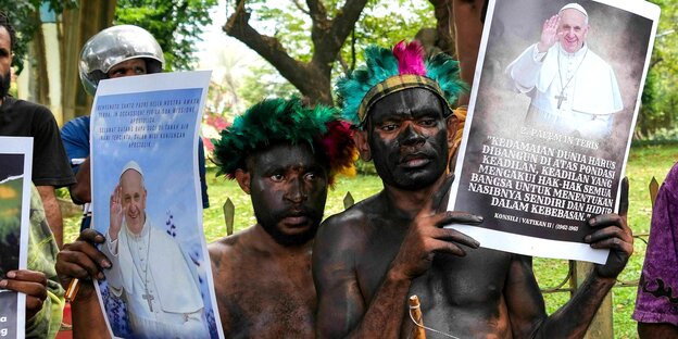 Papua-Studenten in traditioneller Kleidung halten Plakate mit Bildern des Papstes während einer Protestaktion vor der Vatikanischen Botschaft in Jakarta